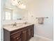 Bathroom vanity featuring double sinks, dark wood cabinetry, and a large framed mirror at 2213 Ravens Creek Ct, Raleigh, NC 27603