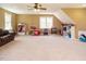 Expansive carpeted bonus room with ceiling fan, lots of natural light, and play space at 2213 Ravens Creek Ct, Raleigh, NC 27603
