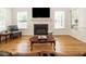 Bright living room featuring a fireplace, hardwood floors, and an open layout at 2213 Ravens Creek Ct, Raleigh, NC 27603