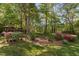 Tranquil backyard with lush greenery, a gazebo, and colorful azalea bushes at 2221 Dungiven Ct, Garner, NC 27529