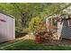 Landscaped backyard featuring mature trees, blooming azaleas, and a storage shed at 2221 Dungiven Ct, Garner, NC 27529
