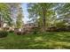 Large backyard with mature trees, lush lawn, a wooden gazebo, and a shed at 2221 Dungiven Ct, Garner, NC 27529