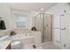 Bright bathroom with soaking tub, glass shower, neutral tile and fixtures, and white cabinets at 2221 Dungiven Ct, Garner, NC 27529