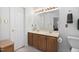Neutral bathroom featuring dual sinks, wood vanity, large mirror, and recessed lighting at 2221 Dungiven Ct, Garner, NC 27529