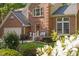 Charming brick home with a cozy front porch, lush greenery, and a well-manicured lawn at 2221 Dungiven Ct, Garner, NC 27529