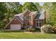 Well-maintained brick home with lush landscaping, mature trees, and an attached two-car garage at 2221 Dungiven Ct, Garner, NC 27529