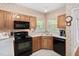 Well-lit kitchen with ample counter space, black appliances, and wooden cabinets at 2221 Dungiven Ct, Garner, NC 27529