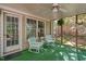 Enclosed porch with striped seating and green carpet at 2221 Dungiven Ct, Garner, NC 27529