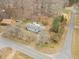 Aerial view of a home, a road, and wooded area in a residential neighborhood in autumn at 2670 Turner Rd, Mebane, NC 27302