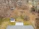 Aerial view of a home's roof, storage shed, wooded area, and backyard in a residential neighborhood at 2670 Turner Rd, Mebane, NC 27302