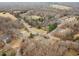 Aerial view of homes, a road, and wooded areas in a rural residential neighborhood in autumn at 2670 Turner Rd, Mebane, NC 27302