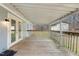 Covered wooden back porch with wood railing overlooking the backyard at 2670 Turner Rd, Mebane, NC 27302
