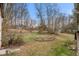 View of the home's backyard with circular landscaping feature and dormant lawn at 2670 Turner Rd, Mebane, NC 27302