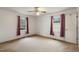 Bedroom with neutral carpet, white walls and two bright windows with burgundy curtains at 2670 Turner Rd, Mebane, NC 27302