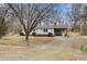 Quaint single story house with a gravel driveway, covered parking, and a brick chimney at 2670 Turner Rd, Mebane, NC 27302