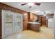Functional kitchen featuring retro flooring, wood paneling, and access to a screened porch at 2670 Turner Rd, Mebane, NC 27302
