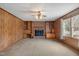 Comfortable living room with wood paneling, built-in bookcases, and a brick fireplace at 2670 Turner Rd, Mebane, NC 27302