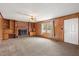 Cozy living room features wood paneling, built-in bookshelves, and a brick fireplace at 2670 Turner Rd, Mebane, NC 27302