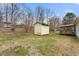 A backyard storage shed, framed by the home, trees, and partially dormant lawn at 2670 Turner Rd, Mebane, NC 27302
