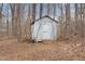 A dilapidated backyard shed surrounded by trees, underbrush, and dormant lawn at 2670 Turner Rd, Mebane, NC 27302