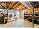 Utility area featuring laundry and shelving in the unfinished basement with painted walls and floors at 2700 Chub Lake Rd, Roxboro, NC 27574
