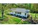 Quaint single-story home featuring a metal roof, freshly painted siding, and a lush green lawn with a landscaped walkway at 2700 Chub Lake Rd, Roxboro, NC 27574