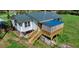 Exterior view of a home with a new deck, surrounded by a fenced yard and a landscaped garden at 2700 Chub Lake Rd, Roxboro, NC 27574