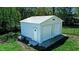 Outbuilding with dual doors, concrete entry, and white paint finish offering outdoor storage solutions at 2700 Chub Lake Rd, Roxboro, NC 27574