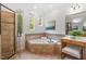 Bathroom with a glass shower, jetted tub, and a vanity with a padded stool at 2900 Old Trafford Way, Raleigh, NC 27606