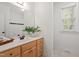 Bathroom featuring light wood cabinets and a white sink, with a window providing natural light at 2900 Old Trafford Way, Raleigh, NC 27606