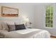 Bright bedroom featuring a large window with outside views and cozy decor at 2900 Old Trafford Way, Raleigh, NC 27606