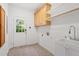 Functional laundry room with sink, cabinetry, and exterior access door at 2900 Old Trafford Way, Raleigh, NC 27606