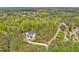 An aerial view of a white two-story home with lush landscaping and mature trees at 30 Mist Wood Ct, Pittsboro, NC 27312