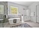 Elegant bathroom features a standalone tub, marble accents, and a view of nature at 30 Mist Wood Ct, Pittsboro, NC 27312