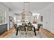 This bright dining area boasts a modern chandelier and leather chairs next to an open, updated kitchen and staircase at 30 Mist Wood Ct, Pittsboro, NC 27312