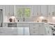 Bright kitchen with white cabinetry, stainless steel appliances, and a view of the outdoor scenery at 30 Mist Wood Ct, Pittsboro, NC 27312