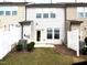 Townhome backyard featuring a small patio, landscaping, and white fence at 3007 Cypress Lagoon Ct, Durham, NC 27703