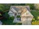Aerial view of home featuring a manicured lawn, patio with seating, and a two-car garage at 308 Grove Hall Ln, Mebane, NC 27302