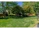 The backyard displays a well-maintained lawn with trees and bushes providing a peaceful, private setting at 308 Grove Hall Ln, Mebane, NC 27302