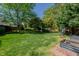Spacious backyard with mature trees and lush lawn, offering ample space for outdoor activities at 308 Grove Hall Ln, Mebane, NC 27302