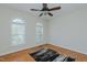Bright bedroom with arched windows, ceiling fan, hardwood floors, and modern area rug at 308 Grove Hall Ln, Mebane, NC 27302