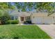 Charming home featuring a red front door, attached garages, well-manicured lawn and inviting front porch seating area at 308 Grove Hall Ln, Mebane, NC 27302