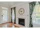 Living room featuring gleaming hardwood floors, a fireplace, and a door leading to an outdoor deck at 308 Grove Hall Ln, Mebane, NC 27302