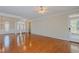 Spacious living room boasts gleaming hardwood floors, bright windows, and a ceiling fan at 308 Grove Hall Ln, Mebane, NC 27302
