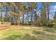 Lush backyard with mature trees and open grassy area, adjacent to a wooden deck at 3100 Greenville Loop Rd, Wake Forest, NC 27587
