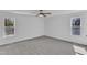 Light-filled bedroom featuring neutral carpeting, two windows, and white walls at 3100 Greenville Loop Rd, Wake Forest, NC 27587