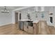 Open kitchen view with kitchen island, stainless steel sink and dishwasher, and access to living space at 3100 Greenville Loop Rd, Wake Forest, NC 27587