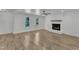 Living room with white brick fireplace, wood mantel, ample windows, and wood floors at 3100 Greenville Loop Rd, Wake Forest, NC 27587
