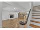 Open concept living area featuring staircase, fireplace, kitchen island, and hardwood floors at 3100 Greenville Loop Rd, Wake Forest, NC 27587