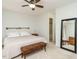 Neutral bedroom featuring a bed, padded bench, and view to bathroom at 3125 Morningside Dr, Raleigh, NC 27607